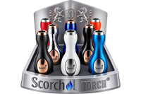 A display stand showcasing multiple portable electric torch lighters by Scorch Torch, including black, silver, white, blue, and red color options, set against a plain white background.