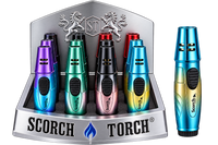 A display of Scorch Torch lighter matches in multiple metallic colors, including purple, green, black, pink, and blue, shown inside a branded silver display stand with a single lighter standing beside it on a white background.